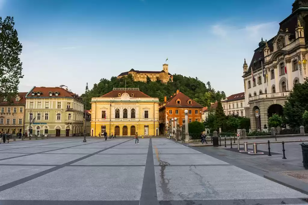 Scenic view of Ljubljana's central square with historical architecture and Ljubljana Castle in the background.