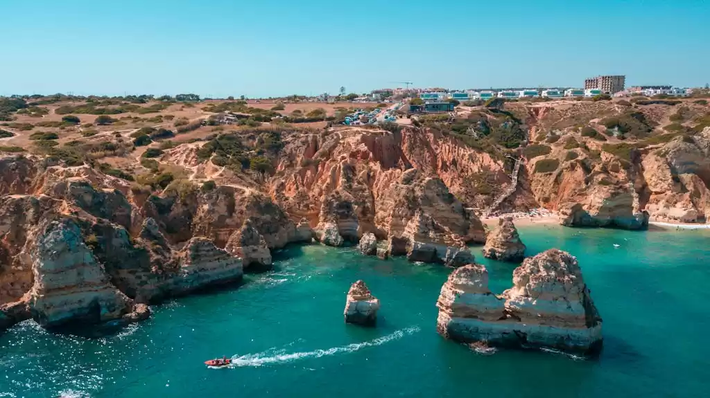 Stunning aerial shot of the rocky coastline in Lagos, Portugal's Algarve region, with clear blue sea.