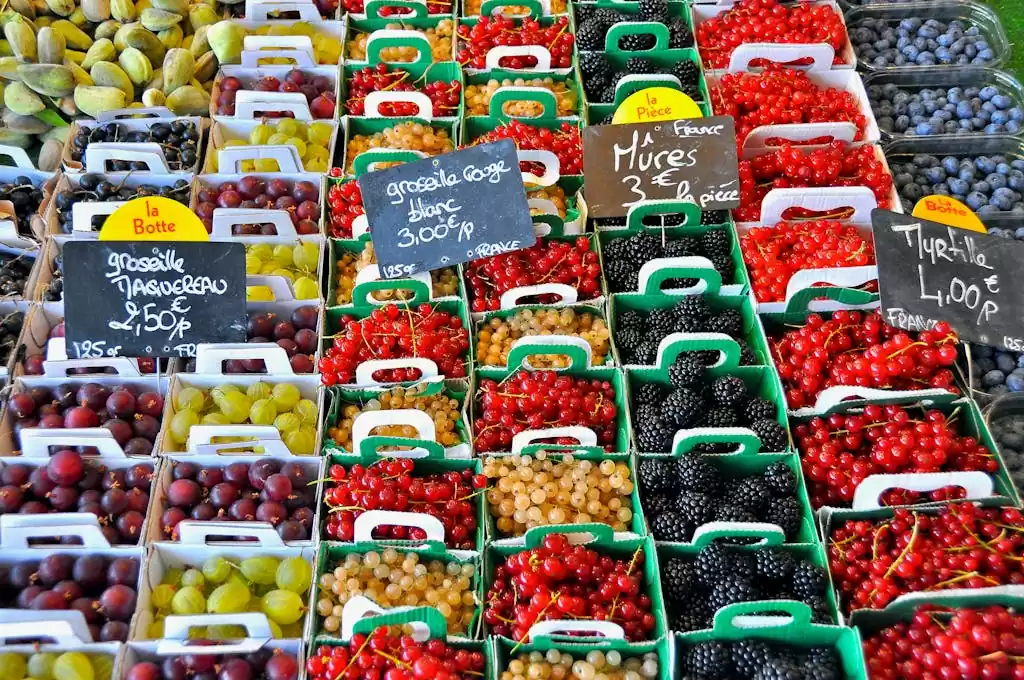 A vibrant display of assorted berries for sale at a market in Le Bois-Plage-en-Ré, France.