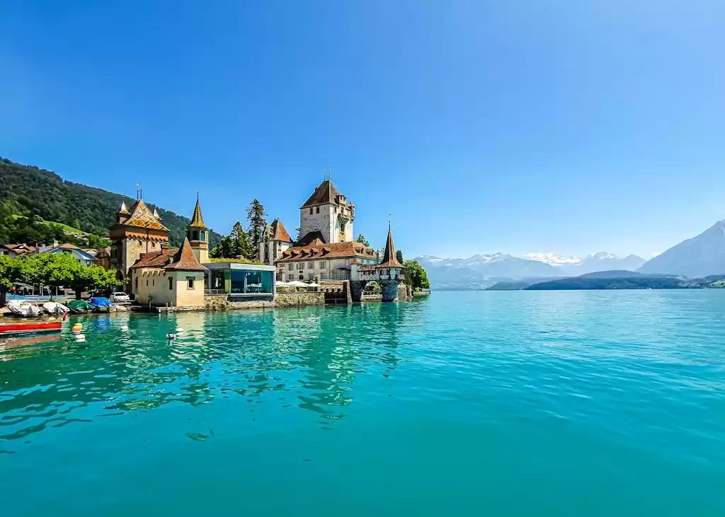 Experience the enchanting Oberhofen Castle on the turquoise shores of Lake Thun in Switzerland.