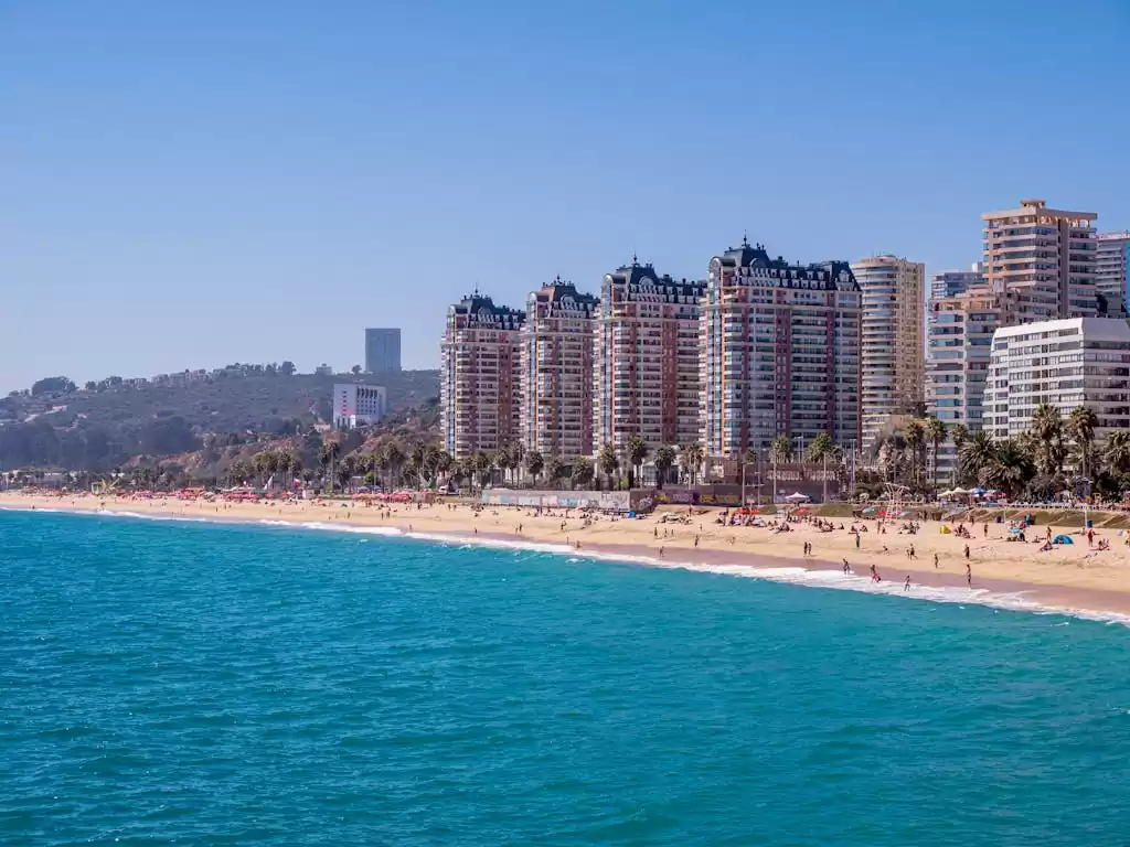 View of Viña del Mar's sunny coastline with bustling beachfront and high-rise buildings.