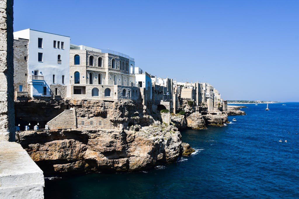 Beautiful cliffside view of Polignano a Mare, Italy with blue sea and sky.