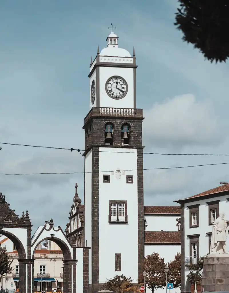 Iconic clock tower in Ponta Delgada, Azores, captured against a blue sky, showcasing Portuguese architecture.