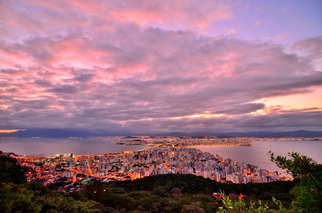 Breathtaking view of Florianópolis, Brazil at sunset, showcasing cityscape and ocean under vibrant sky.