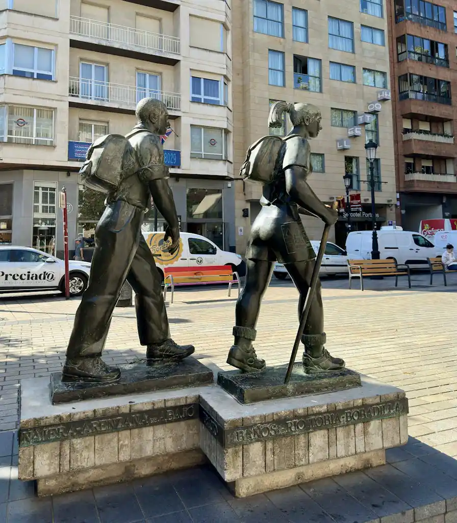 Bronze statues of pilgrims on the Camino de Santiago in Logroño, Spain's vibrant urban setting.