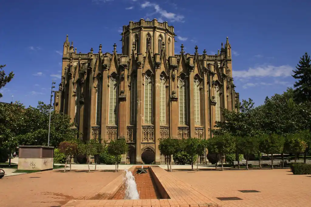Exterior view of a Gothic Revival cathedral under a clear blue sky in Vitoria-Gasteiz, España.