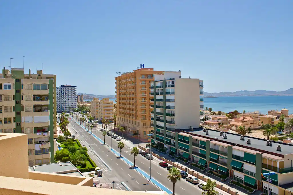 Stunning daytime aerial shot of La Manga's coastline, capturing the vibrant cityscape and sea.