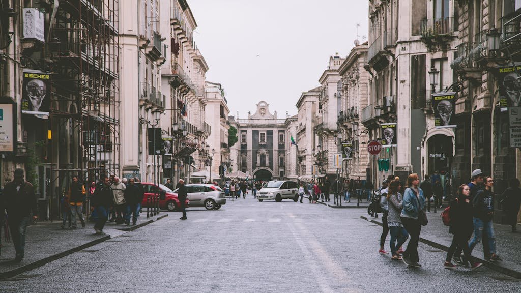 Lively urban scene of a historic street in Catania, Sicily showcasing architecture and daily life.