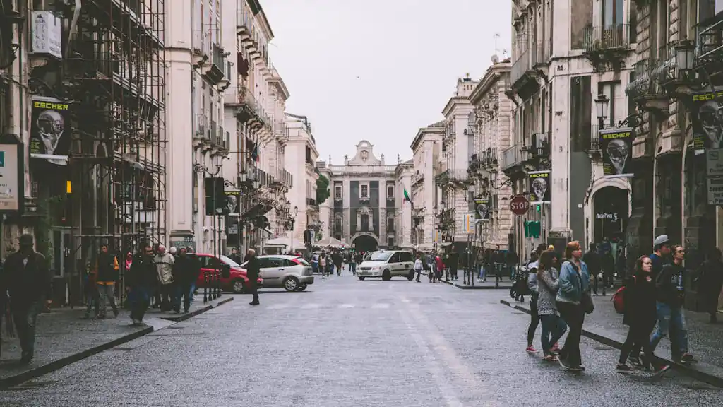 10 Best French Cities to Retire to in 2026 | Best Places to Live in France: Pros, Cons, & Costs 4 Lively urban scene of a historic street in Catania, Sicily showcasing architecture and daily life.